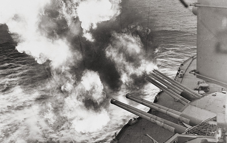 Forward guns of the USS Nevada fire on German positions along Utah Beach.