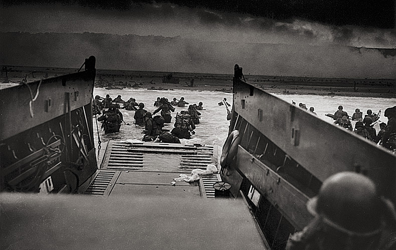 Vulnerable American invaders wade the perilous distance from their landing craft to the beach. German machine-gun fire will cut some of them down. Their landing craft then pulls itself off the sands and dashes back to a Coast Guard transport for more troops -- repeating this from dawn till dark and then into the night.