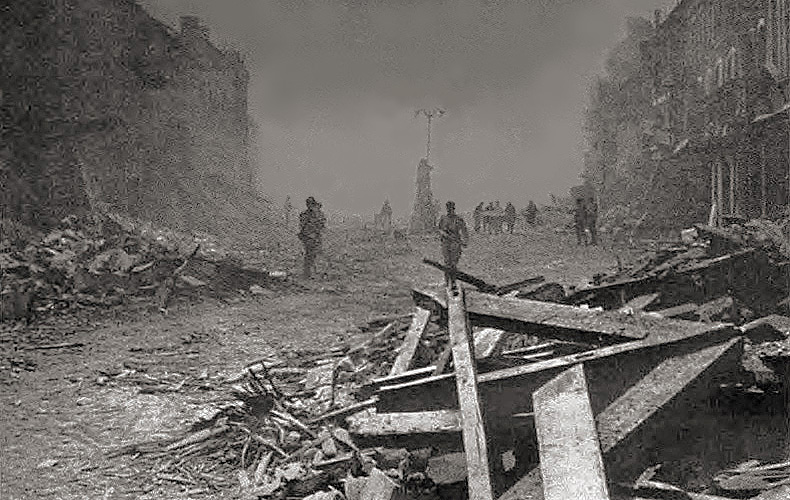 Americans move through the heavily damaged town of Insigny in the early morning of June 9th, following an intensive naval bombardment. Although they encountered little organized resistance, German riflemen were still sniping from wrecked houses later in the day. 