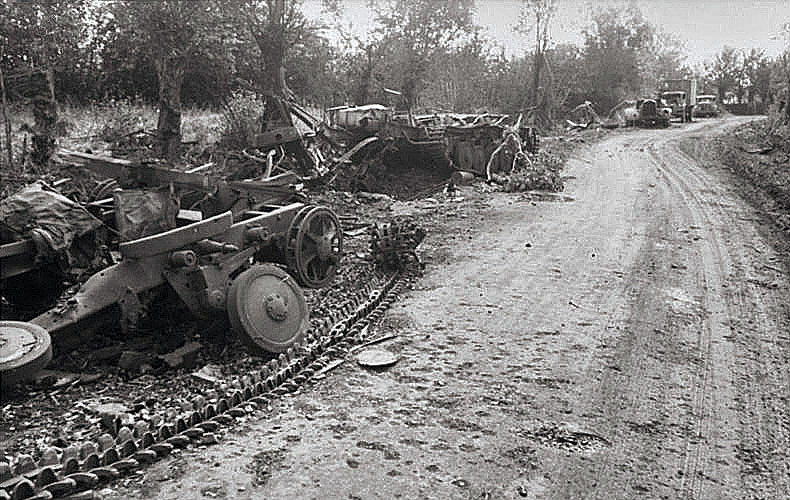 A long line of destroyed German vehicles along a French highway.