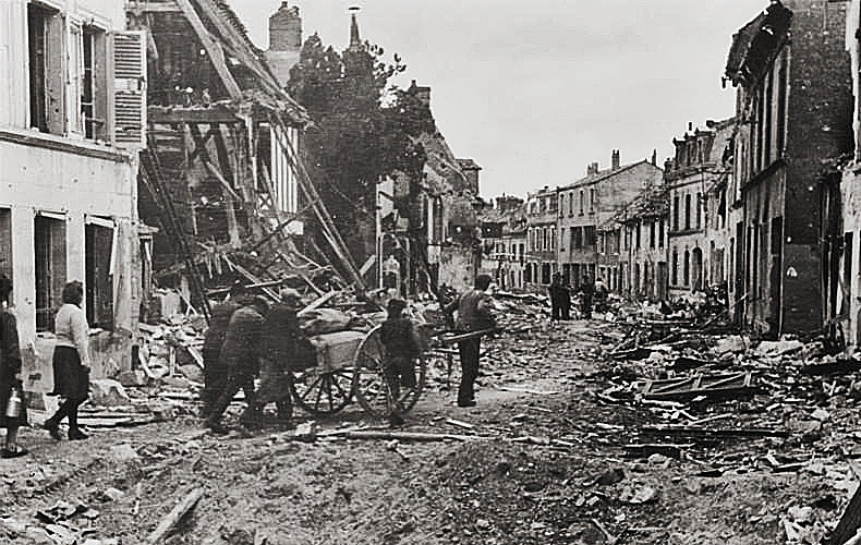 French civilians traverse through a heavily damaged city along the Normandy coast.