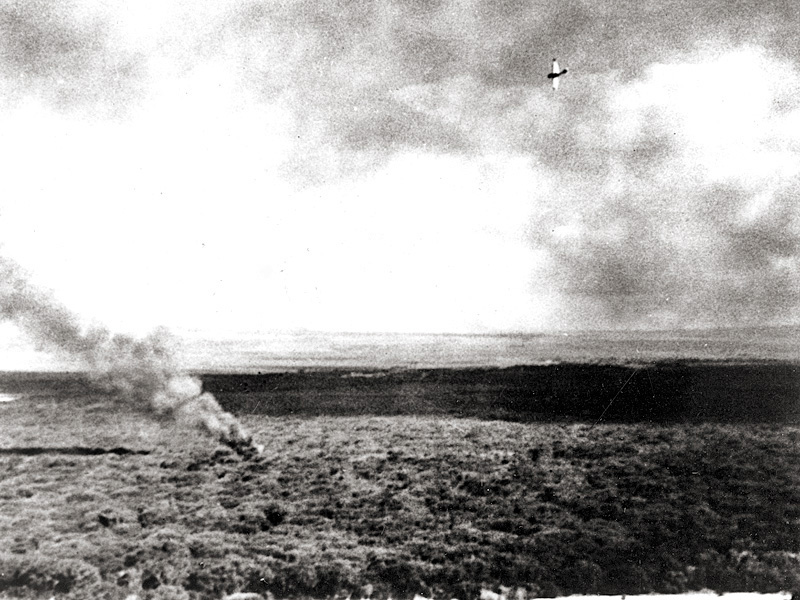 A Japanese Navy plane circles a crashed aircraft north of Ewa Beach, Oahu, during the raid. The burning plane is probably from USS Enterprise. A Japanese plane crashed in the same location, with its wreckage intermingled with that of the U.S. Navy aircraft. 