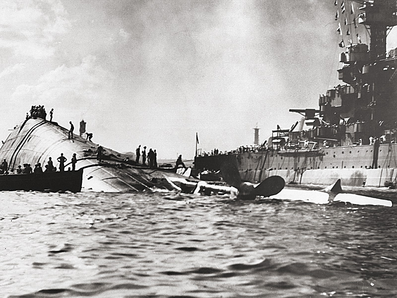 The capsized USS Oklahoma and the USS Maryland seen after the attack.