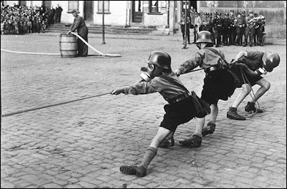 Air-raid training for Jungvolks involves a rope tug with gas masks.