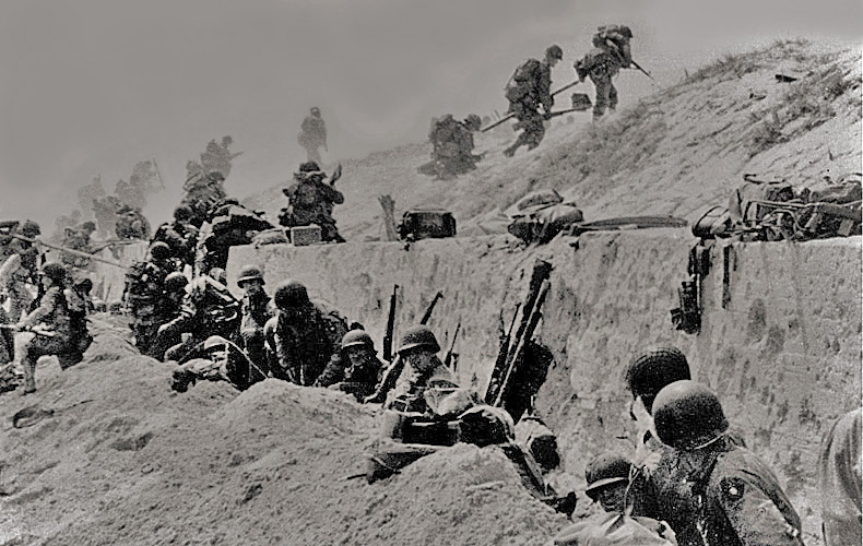 Soldiers of the 4th Infantry Division move out over a seawall.