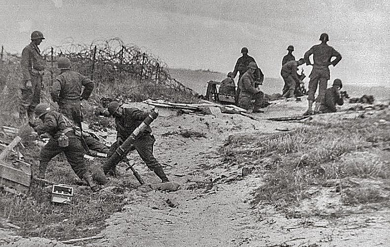 A mortar crew stands back just before firing into a Nazi position.
