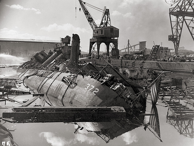 USS Cassin burned out and capsized against USS Downes in the Navy Yard drydock.