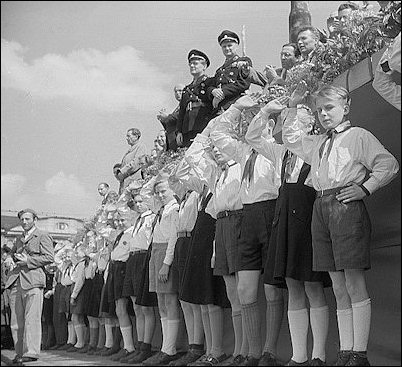 Communist Era--Young Pioneers in East Germany attend a political rally in 1951, displaying their unique bent-elbow hand salute, designed to contrast with the former straight-armed Hitler salute. 