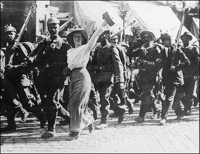 Young German men march off to World War I in August 1914 with flowers in their rifle barrels and much jubilation.